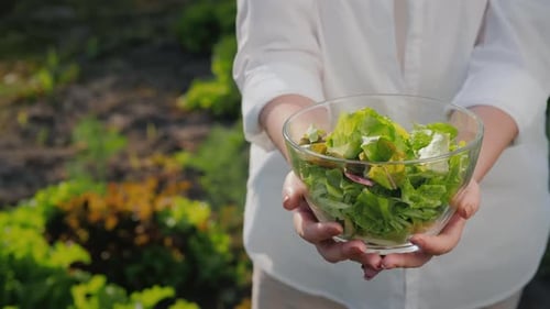 Holding Fresh Salad Bowl in Garden
