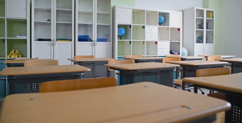 Empty Classroom with Desks and Bookshelves
