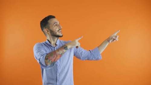Man Pointing Upward on Orange Background