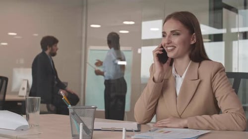 Smiling Woman Talking on Phone in Modern Office