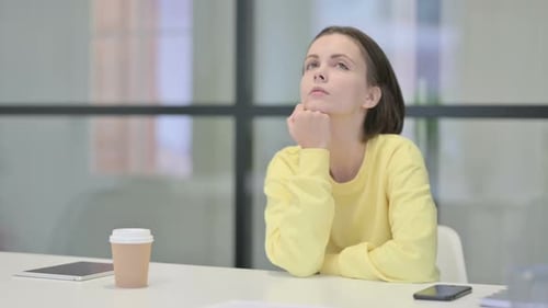 Pensive Young Woman Thinking While Sitting in Office