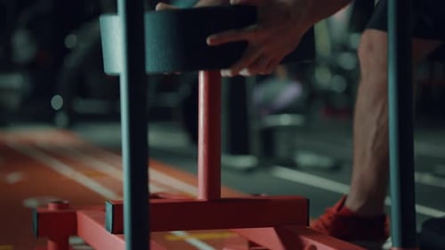 Barbell Plates Put on Exercise Stand By Strong Man