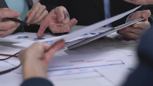 Business Meeting Analyzing Financial Charts and Reports
