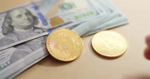 Gold Bitcoins Placed by Stack of Dollar Bills