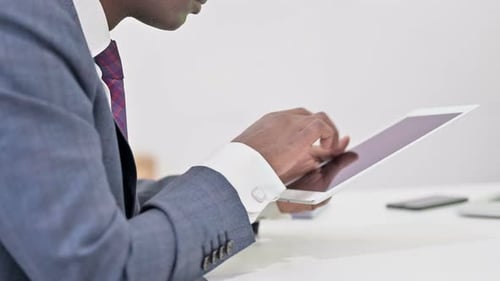 Close Up of Professional African Businessman Working on Tablet
