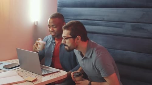 Men Collaborating at Work with Laptop and Coffee