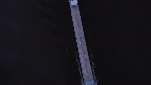 Cargo Barge With Commodities Sailing In River Noord At Dusk In Netherlands. - Aerial Topdown Shot