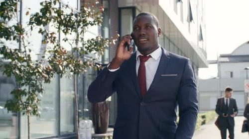 Businessman Walking on Street and Talking on Phone