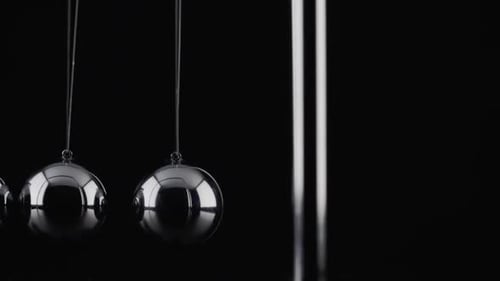 Die Kugeln einer Newtons Cradle kollidieren in Zeitlupe