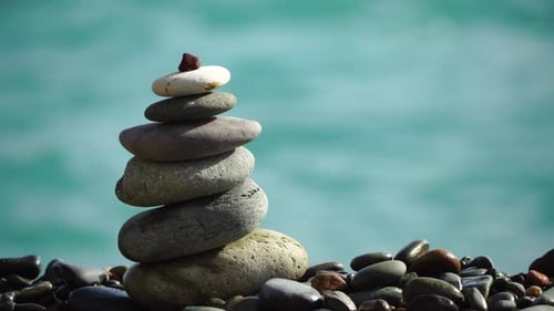 Balanced Pebbles Pyramid on the Beach on Sunny Day and Clear Sky at Sunset