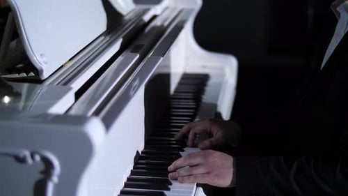 Man Plays Grand Piano in Dark Environment
