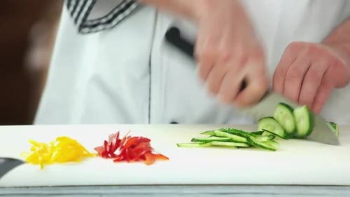 Chef Slices Cucumber on Cutting Board