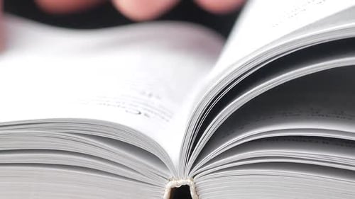 Person turning the page of a book up close. read a book
