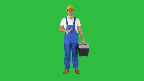 Ein Mechaniker mit Werkzeugkiste und Schraubenschlüssel lächelt in die Kamera