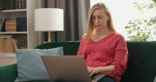 Woman Using Laptop at Home on Couch