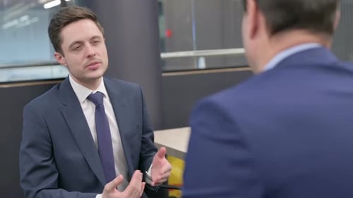 Rear View of Businessman Talking to Colleague in Office