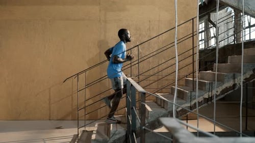 Man Jogging Up Concrete Stairs Indoors