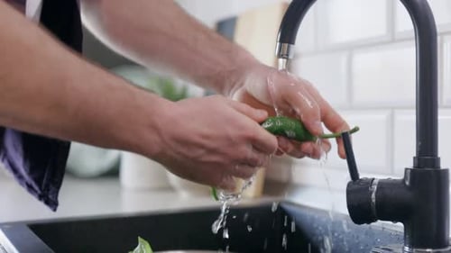 Hands Washing Green Pepper in Kitchen Sink