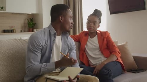 Une famille afro-américaine des années 20 discute de ses plans et les note dans le bloc-notes