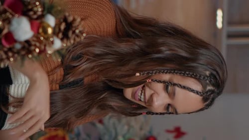 Woman Decorating Christmas Tree with Mug in Hand