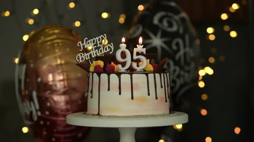 Birthday Cake with Candles and Balloons at Night