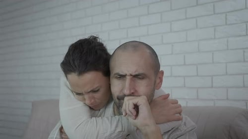 Distressed Couple Embracing Indoors