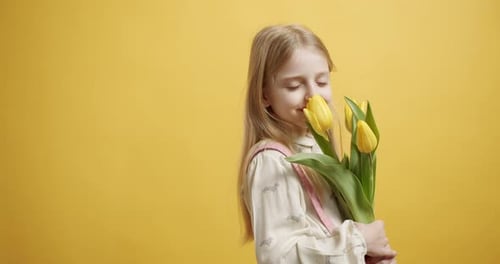 Smiling Girl Holding Bouquet of Yellow Tulips