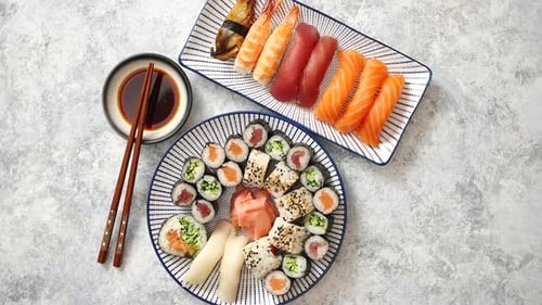 Surtido de comida asiática. Varios rollos de sushi colocados en platos de cerámica