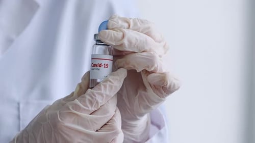 Gloved Hand Holds Covid-19 Vaccine