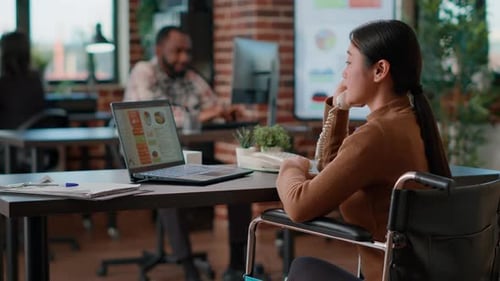 Businesswoman in Wheelchair Working at Desk in Office