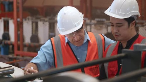 Engineer teaching apprentice to use metal sheet stamping machine