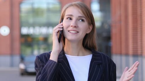 Young Woman Talking on Phone in Urban Setting