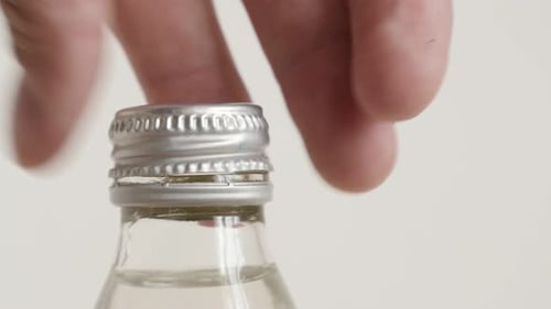 Metal cap taking from bottle of water close-up 4K footage