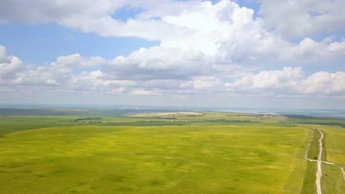 Aerial View of Green Fields and Dirt Road