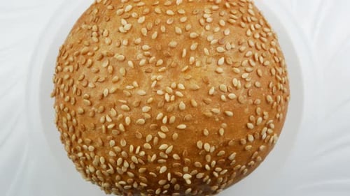 Rotating Burger Bun with Sesame Seeds on Plate