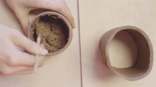 Ceramist Mixing Raw Clay in Workshop