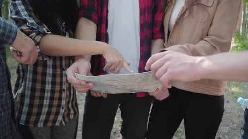 Friends Reading Map in a Forest