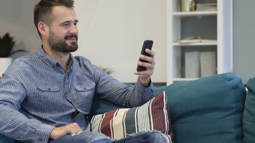 Man Enjoying Video Call on Smartphone at Home