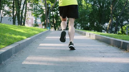 Legs of Jogger Running in Park