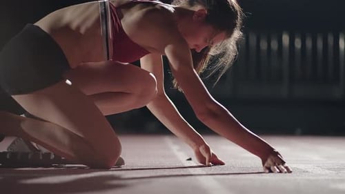 Female Athlete Training at Running Track in the Dark Stadium