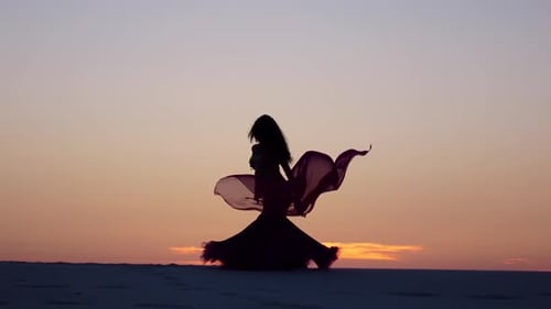 Woman Dances Gracefully with Fabric at Sunset in Desert