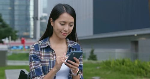 Woman look at mobile phone in city