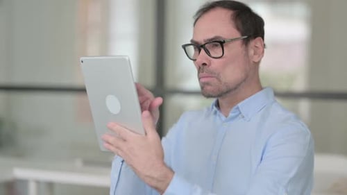 Portrait of Middle Aged Man Using Tablet in Office