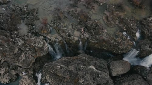 Aerial view of Man walking through the stone of Niagara Waterfall on the river Cijevna