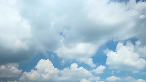 Fluffy White Clouds Moving Across a Blue Sky