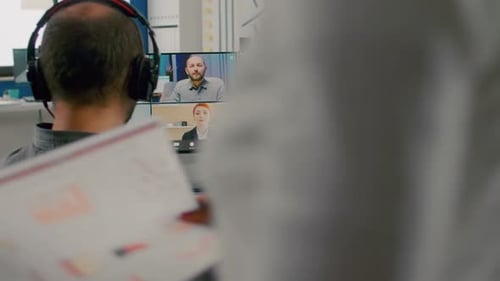 Man Editing Video on Dual Monitors in Office