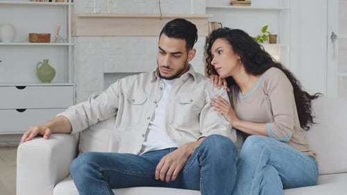 Comforting Woman Supporting Upset Man on Couch Indoors