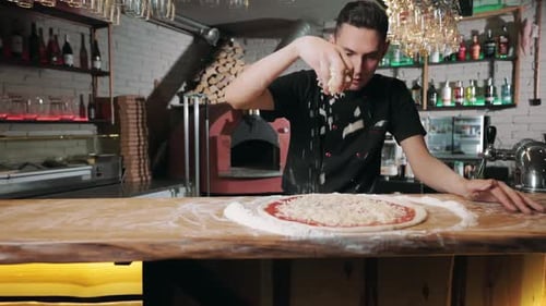 Chef Cook Putting Grated Cheese on Pizza Dough