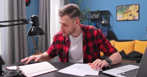 Man Reviews Documents at Desk