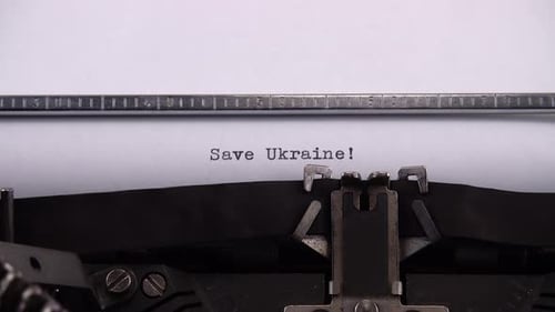 Typing phrase "Save Ukraine !" on retro typewriter.